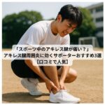 アキレス腱を押さえてうずくまる高校生男子スポーツ選手