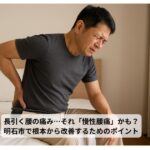 ベッドに座って腰を押さえる中年男性
